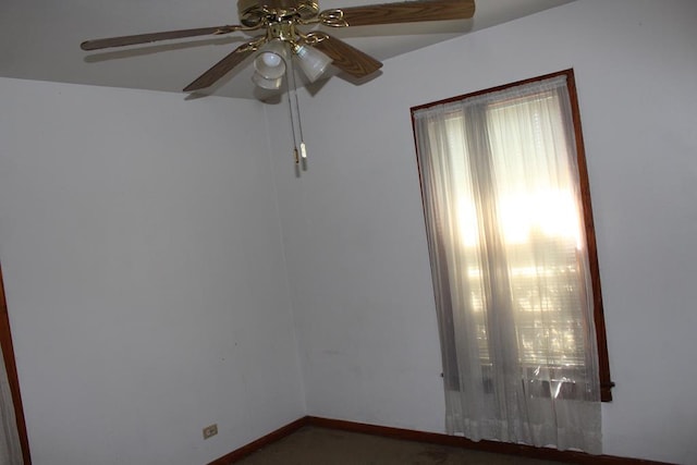 empty room featuring ceiling fan and baseboards