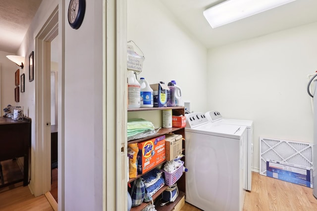 washroom with laundry area, separate washer and dryer, and wood finished floors