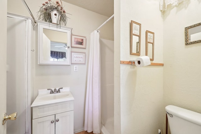 bathroom featuring curtained shower, vanity, and toilet