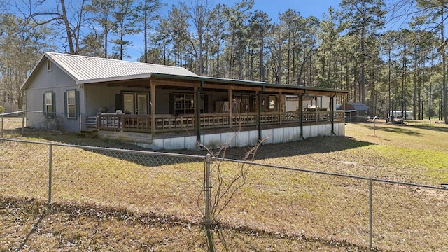 view of front facade featuring a front yard, metal roof, and fence