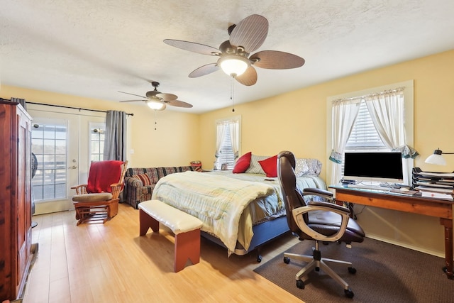 bedroom featuring a textured ceiling, a ceiling fan, and wood finished floors