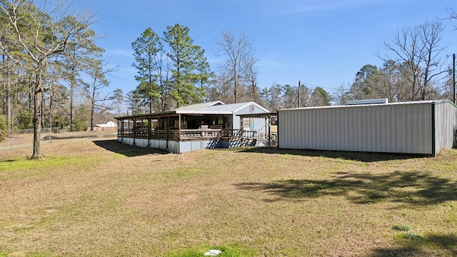 back of house with an outbuilding and a yard