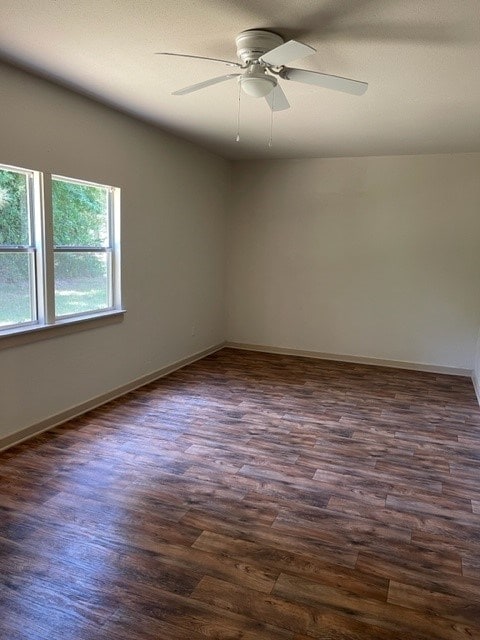 spare room featuring ceiling fan and dark wood-type flooring