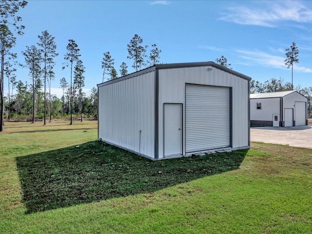 view of outdoor structure with a lawn and a garage