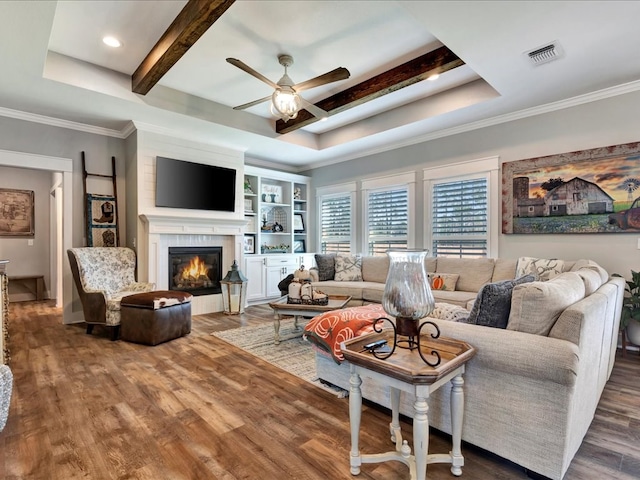 living room with beam ceiling, a tile fireplace, ceiling fan, and hardwood / wood-style flooring