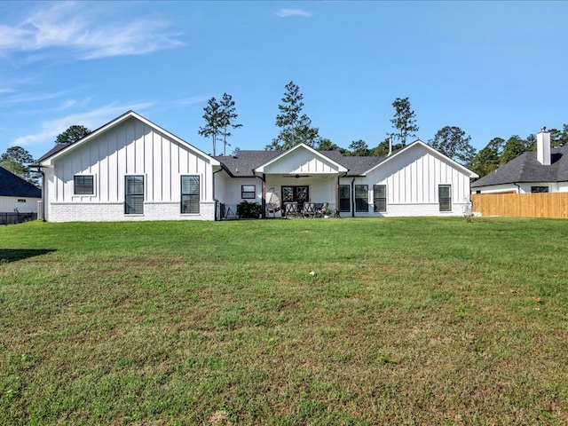 rear view of house with a lawn and ceiling fan