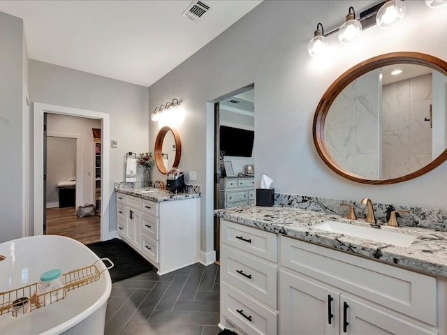 bathroom featuring a bathing tub, tile patterned flooring, and vanity