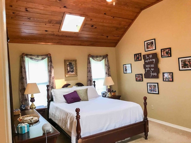 carpeted bedroom featuring lofted ceiling with skylight and wooden ceiling