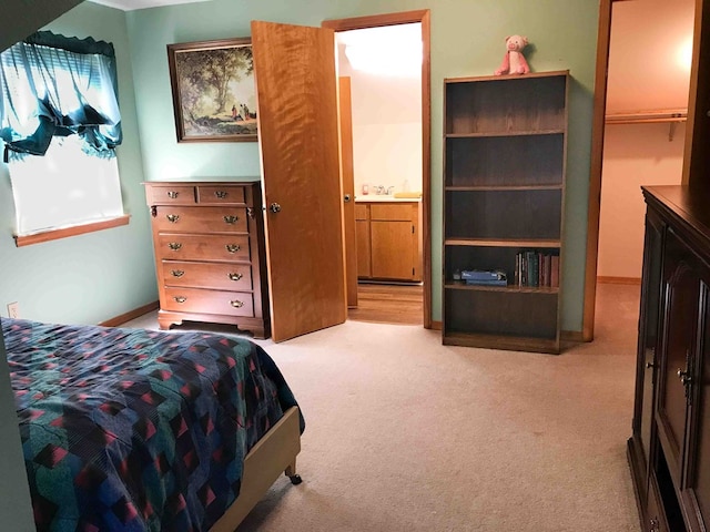 bedroom featuring a spacious closet, a closet, and light colored carpet