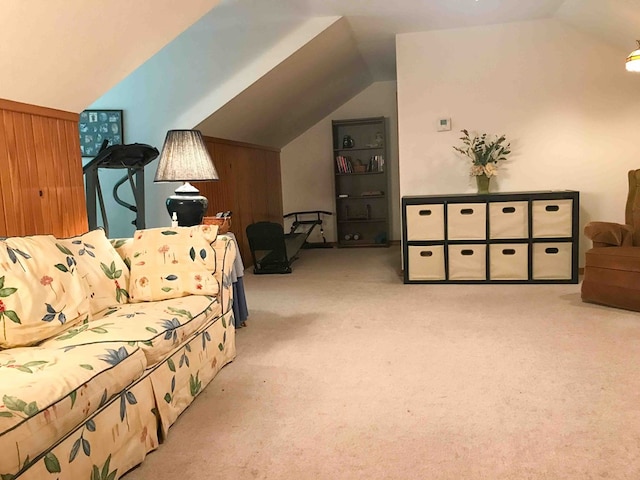 interior space with light carpet, vaulted ceiling, and wooden walls