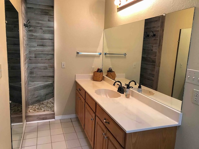 bathroom with tile patterned floors, vanity, and a tile shower