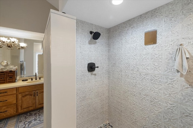 bathroom featuring vanity, a tile shower, and an inviting chandelier