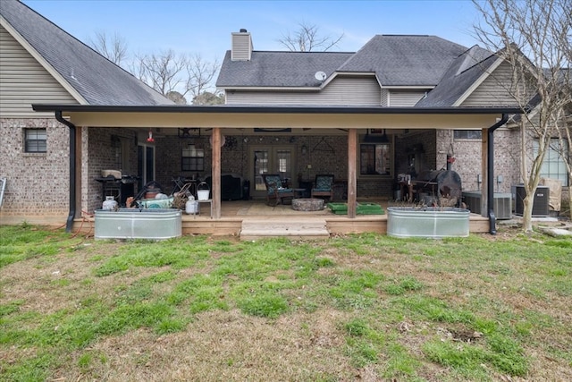 back of house featuring french doors, a deck, central air condition unit, and a lawn