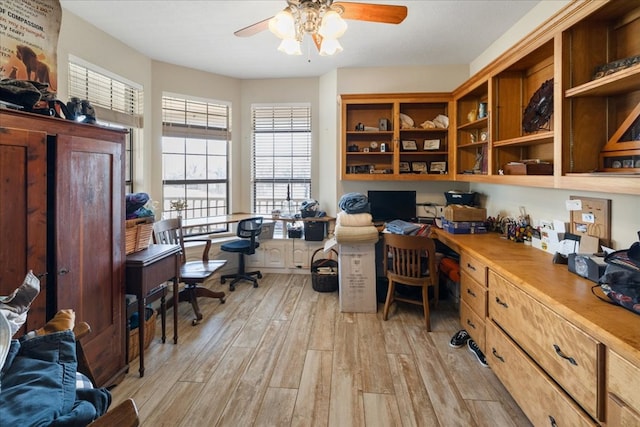 home office featuring ceiling fan, light hardwood / wood-style floors, and built in desk