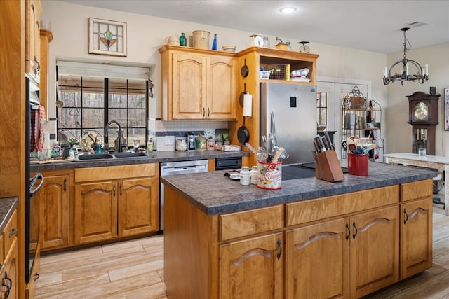 kitchen with dishwashing machine, light hardwood / wood-style flooring, a kitchen island, stainless steel refrigerator, and sink