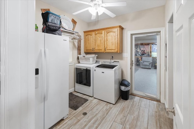 washroom with cabinets, washing machine and dryer, ceiling fan, and light hardwood / wood-style flooring