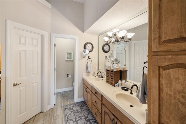 bathroom featuring a chandelier, vanity, and toilet