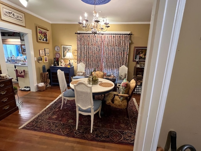 dining space featuring crown molding, hardwood / wood-style floors, and an inviting chandelier