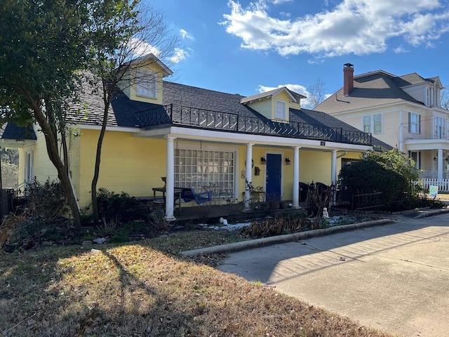 view of front facade with covered porch and a balcony