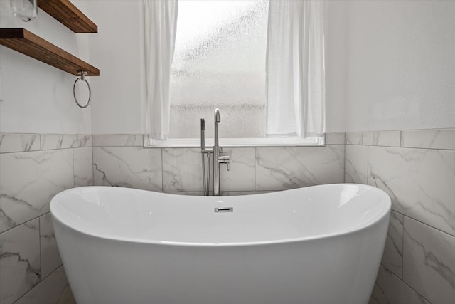 174 Cedar Hill Loop, Lufkin, TX 75904 - bathroom featuring tile walls, wainscoting, and a freestanding bath
