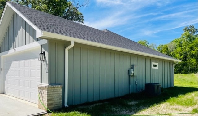 view of side of property featuring cooling unit, an outdoor structure, and a garage