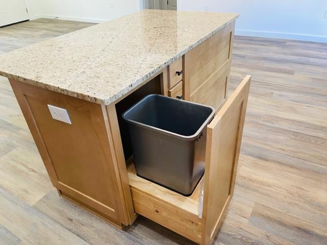 kitchen featuring light stone countertops, a center island, and light hardwood / wood-style floors