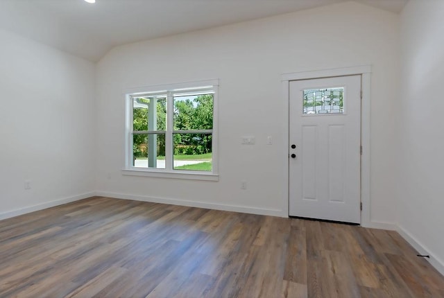 foyer entrance with wood-type flooring and vaulted ceiling