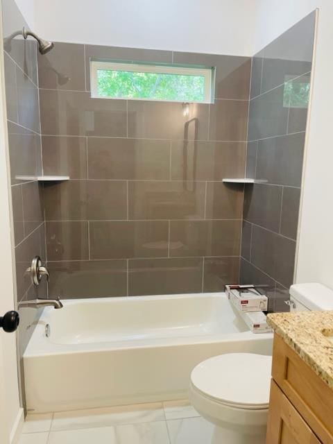 full bathroom with tile patterned floors, vanity, tiled shower / bath combo, and toilet