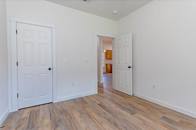 unfurnished bedroom with light hardwood / wood-style flooring and a closet