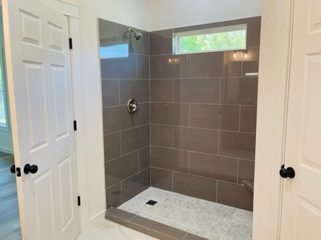 bathroom with tile patterned flooring and a tile shower