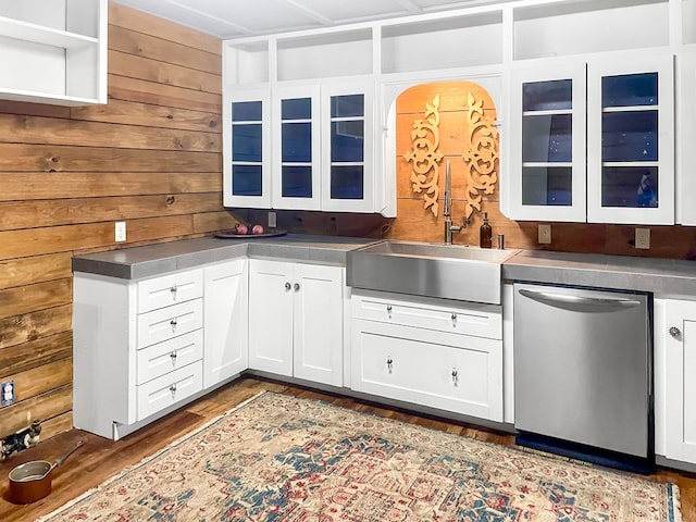 518 Court St, Newton, TX 75966 - kitchen with stainless steel dishwasher, a sink, wooden walls, white cabinets, and wood finished floors