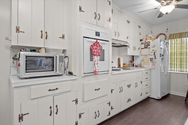 kitchen featuring white cabinetry, dark hardwood / wood-style floors, backsplash, white appliances, and ornamental molding