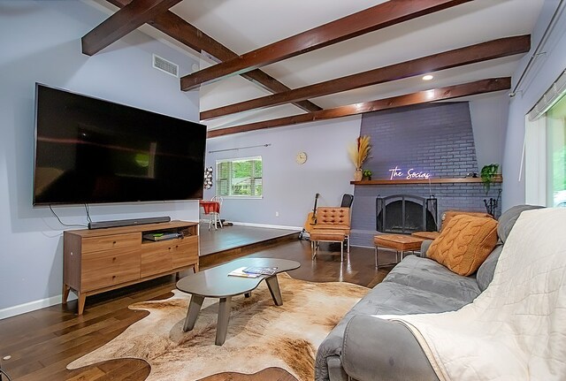 living room with a fireplace, beamed ceiling, and dark hardwood / wood-style floors