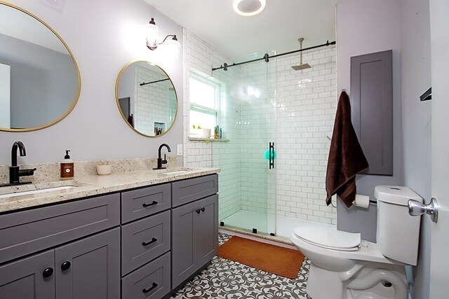 bathroom with tile patterned floors, toilet, vanity, and walk in shower