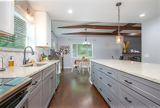 kitchen featuring decorative light fixtures, gray cabinets, light stone counters, and dark wood-type flooring