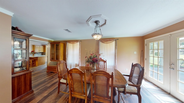 dining space with french doors, dark wood-type flooring, and ornamental molding