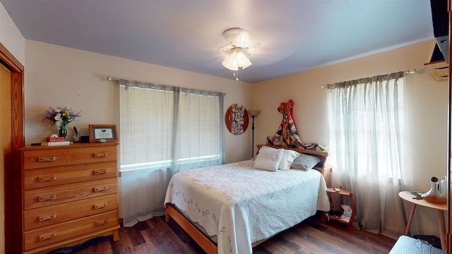 bedroom featuring multiple windows, ceiling fan, and dark hardwood / wood-style flooring