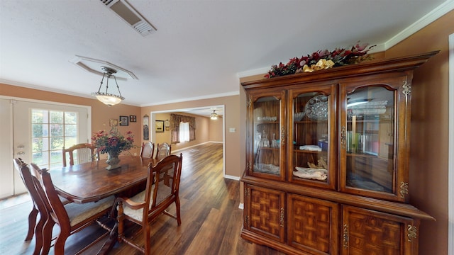 dining area with dark hardwood / wood-style flooring and ornamental molding