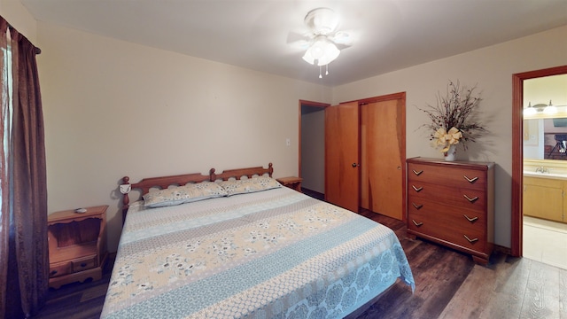 bedroom with ceiling fan, sink, dark wood-type flooring, and ensuite bath