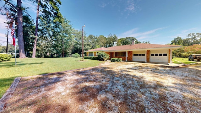 single story home featuring a front lawn and a garage