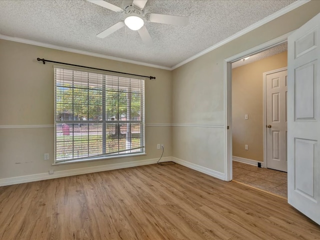 unfurnished room featuring ceiling fan, ornamental molding, a textured ceiling, and light wood-type flooring