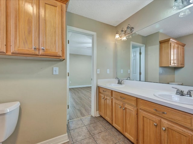 bathroom featuring tile patterned floors, vanity, toilet, and a textured ceiling