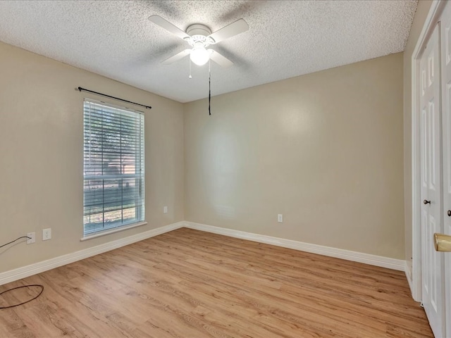 spare room with ceiling fan, a textured ceiling, and light wood-type flooring