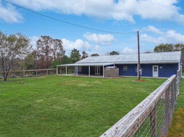 rear view of property with a shed and a lawn