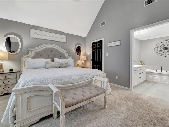 bedroom with connected bathroom, light carpet, and high vaulted ceiling