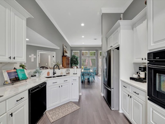 kitchen featuring black appliances, white cabinetry, and sink