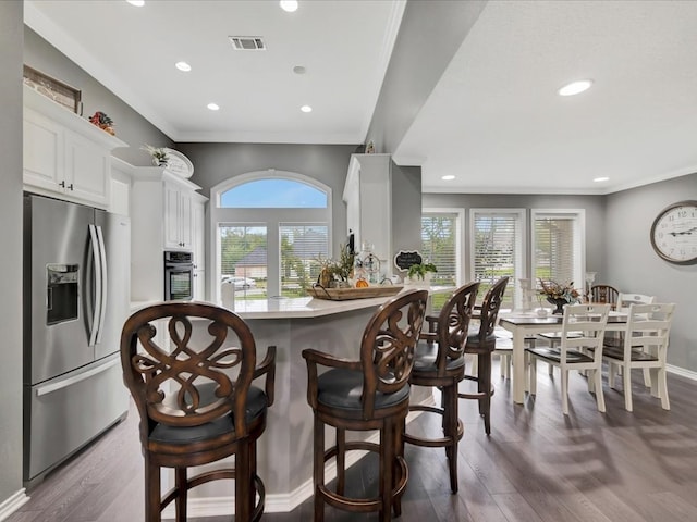 kitchen with dark hardwood / wood-style flooring, plenty of natural light, white cabinets, and appliances with stainless steel finishes