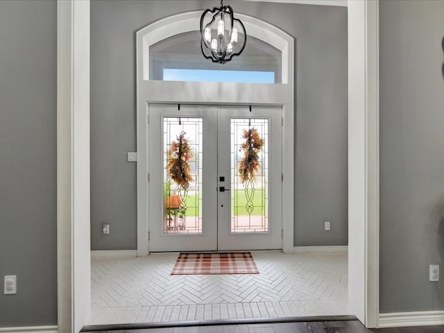 foyer featuring french doors and a notable chandelier