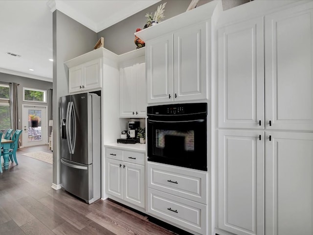 kitchen featuring white cabinets, black oven, stainless steel fridge, and dark hardwood / wood-style floors