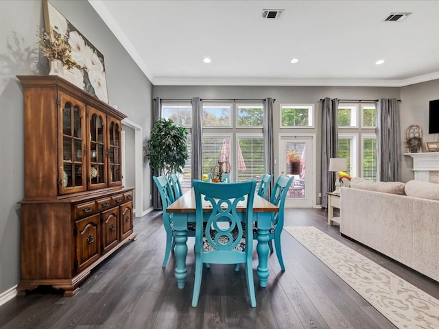 dining space with crown molding, plenty of natural light, and dark wood-type flooring